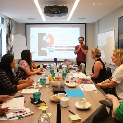 A group of people having a meeting at a boardroom.